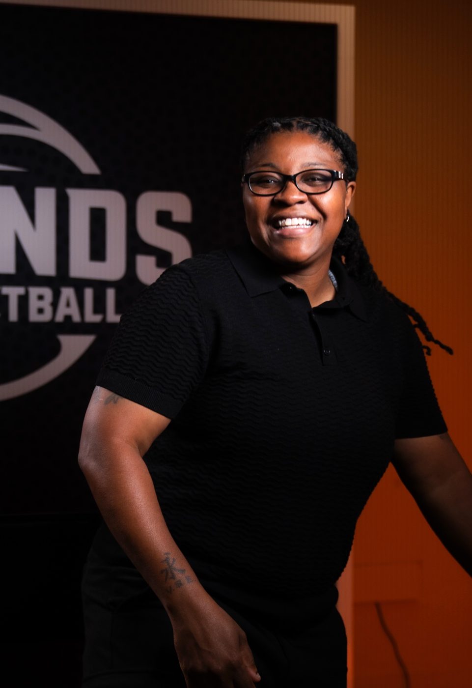 Toccara “Sweet” Williams laughing in front of the Legends of Basketball backdrop